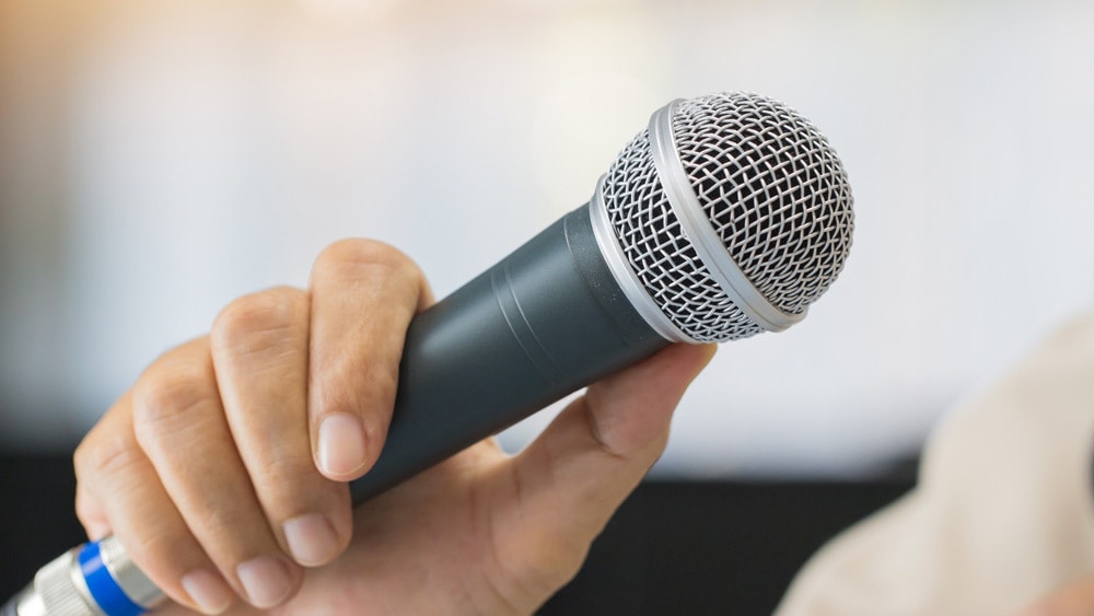 Man holding a microphone - signifies the different types of public speaking